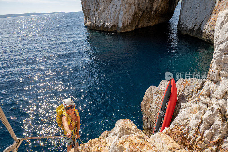 费拉塔岛(Via Ferrata)上的攀登者，年轻的妇女们在攀登海面上的岩石